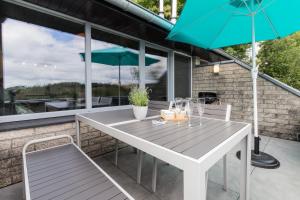 a table and chairs with an umbrella on a patio at La Cabane d'Hujulo in Malmedy