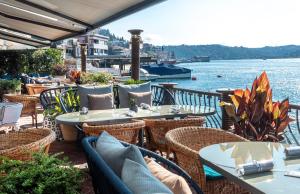 a patio area with tables, chairs and umbrellas at Bebek Hotel By The Stay Collection -Adults Only in Istanbul