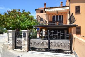 a house with a black gate in front of it at Viola Istra Guest House in Štinjan