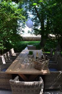 a wooden table with wicker chairs and a table with wine glasses at Bellefleur in Veurne +18 photos