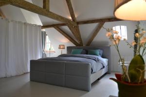 een slaapkamer met een bed in een kamer met houten balken bij Bellefleur in Veurne