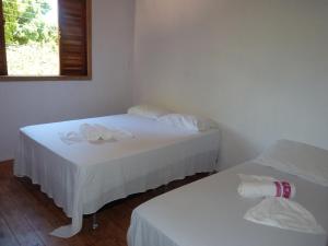 2 camas en una habitación con paredes blancas en Casas da Bete, en Trancoso