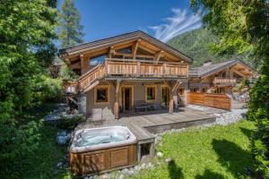 Una casa de troncos con jacuzzi en el patio. en Les Rives d'Argentière, en Chamonix-Mont-Blanc