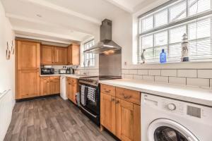 a kitchen with a washer and dryer in it at Lime Kiln Cottage, Pentewan, Cornwall in Pentewan