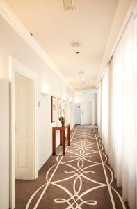 einen Flur mit Teppichboden auf dem Boden und einer Tür in der Unterkunft BRISTOL Hotel Opatija in Opatija