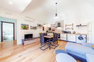 un soggiorno con un tavolo e un divano blu di GuestHost - Vakalu Piazza Duomo Charming Apartment a Siracusa Altre 11 foto