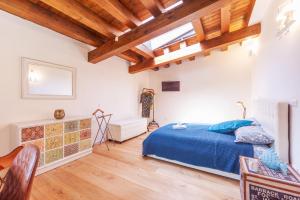 una camera con letto blu e soffitti in legno di GuestHost - Vakalu Piazza Duomo Charming Apartment a Siracusa