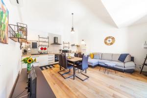 un soggiorno e una cucina con un divano e un tavolo di GuestHost - Vakalu Piazza Duomo Charming Apartment a Siracusa