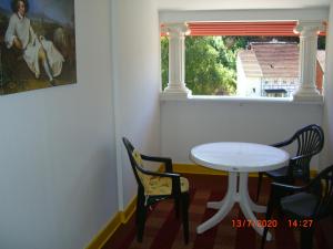einen weißen Tisch und Stühle in einem Zimmer mit Fenster in der Unterkunft Erika's Haus in der Sonne in Bad Grund