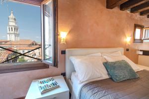 Un dormitorio con una cama y una ventana grande. en Doge Morosini Palace by Wonderful Italy, en Venecia