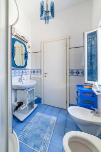 un bagno blu e bianco con lavandino e servizi igienici di La casa del capitano ponza a Ponza