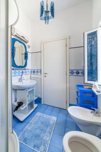 een blauwe en witte badkamer met een wastafel en een toilet bij La casa del capitano ponza in Ponza