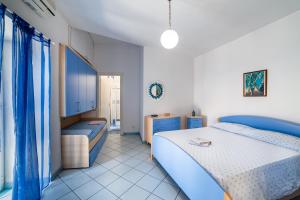 1 dormitorio con 2 camas y cortinas azules en La casa del capitano ponza, en Ponza