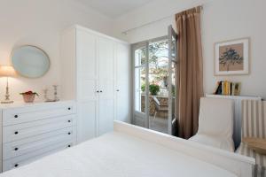 a white bedroom with a dresser and a mirror at Verde Olive Three-Bedroom Holiday Home by Konnect in Kato Korakiana +20 photos