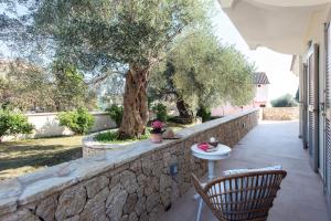 a patio with a stone wall and a table and chairs at Verde Olive Three-Bedroom Holiday Home by Konnect in Kato Korakiana