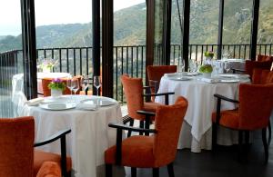 una sala da pranzo con tavoli e sedie e vista di Chateau Eza a Èze