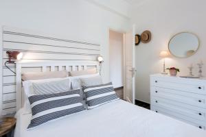 a white bed with striped pillows in a bedroom at Verde Olive Three-Bedroom Holiday Home by Konnect in Kato Korakiana