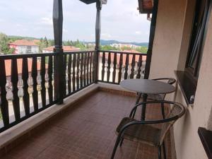 a balcony with a table and two chairs and a window at Family Hotel Demetra in Berkovitsa