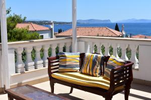 a bench on a balcony with a view of the water at Anamar Villa Kyma Spetses in Spetses