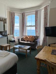 uma sala de estar com um sofá e uma mesa em Clarence House Hotel em Tenby