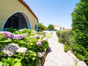 ogród z fioletowymi kwiatami obok budynku w obiekcie La Rotonda Cottages - Klodge w mieście Cala Bitta