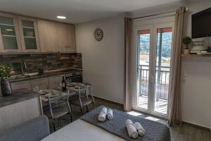 a kitchen with a table and a kitchen with a balcony at Studio Anna in Káto Garoúna