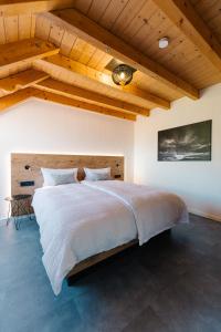 a large bed in a bedroom with wooden ceilings at Moderne 2 Zi.-FeWo BlackForest Art Nähe Freiburg in Simonswald