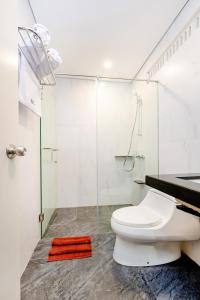 a bathroom with a toilet and a glass shower at Dedanau Hotel in Bedugul