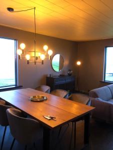 uma sala de jantar com mesa e cadeiras de madeira em Hellnar Ocean View Villa em Hellnar