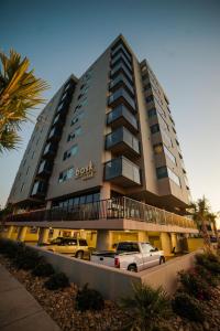 ein großes Gebäude mit davor geparkt in der Unterkunft Bask Hotel at Big Rock Landing in Morehead City