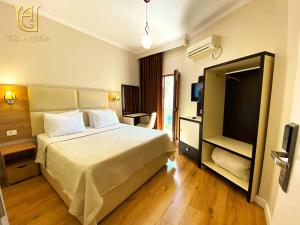 a hotel room with a bed and a television at Hotel Vila e Arte City Center in Tirana