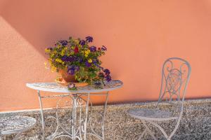 un tavolo e sedie con un vaso di fiori sopra di 01234 - Agriturismo La Marpea, esperienza in mezzo alla natura e al cibo tipico Italiano a Terisso