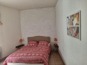 una camera da letto con letto con lenzuola e cuscini rossi di La Colliassoise a Collias