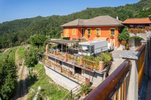 Casa arancione con balcone e tenda di 01234 - Agriturismo La Marpea, esperienza in mezzo alla natura e al cibo tipico Italiano a Terisso