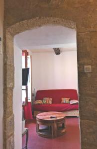 un soggiorno con divano rosso e tavolo di La Colliassoise a Collias