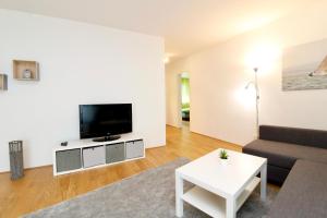 a living room with a couch and a tv at Spacious Terrace Apt in Modern Klosterneuburg Building in Klosterneuburg