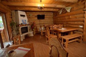a living room of a log cabin with a table and a fireplace at Drin-lux-cotteges in Slavske