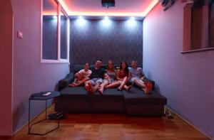 een groep mensen die op een bed in een kamer zitten bij CinemApartman Eger in Eger +4 foto's