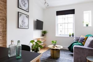 a living room with a couch and a table at Bloomsbury By Viridian Apartments in London