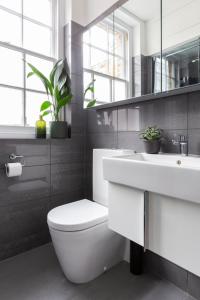 a bathroom with a white toilet and a sink at Bloomsbury By Viridian Apartments in London