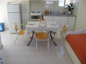 une cuisine avec une table et des chaises dans l'établissement RONZI APARTMANT, à Kamena Vourla