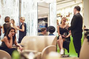 une femme assise sur une chaise dans un dressing dans l'établissement Hotel Josef, à Prague