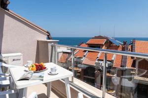 a plate of fruit on a table on a balcony at Amon Ra Hotel in Sozopol