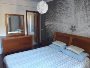 um quarto com uma cama e um espelho grande em Apartamento Marques em Santa Cruz - Madeira