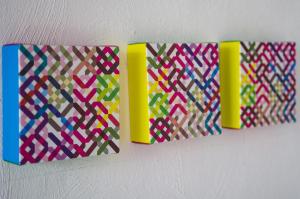 a group of four different colored paper on a wall at Cresta Beach Studios in St. Julianʼs