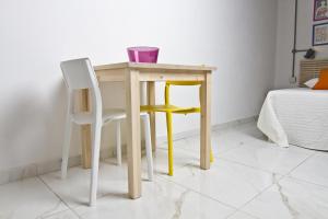 a wooden table and two chairs in a room at Cresta Beach Studios in St. Julianʼs