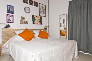um quarto com uma grande cama branca com almofadas laranja em Cresta Beach Studios em St. Julian's