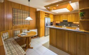 a kitchen with wooden cabinets and a wooden table at Resitour - Kamares Village in Paphos City