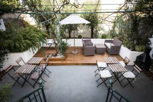 un patio con sillas, mesas y una sombrilla en Carcassonne Townhouse en Carcassonne