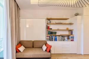 a living room with a couch and a book shelf at GRAND HÔTEL City Center at 2 minutes walk from the beach in Nice